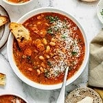 A bowl of fasolada Greek white bean soup garnished with parsley.