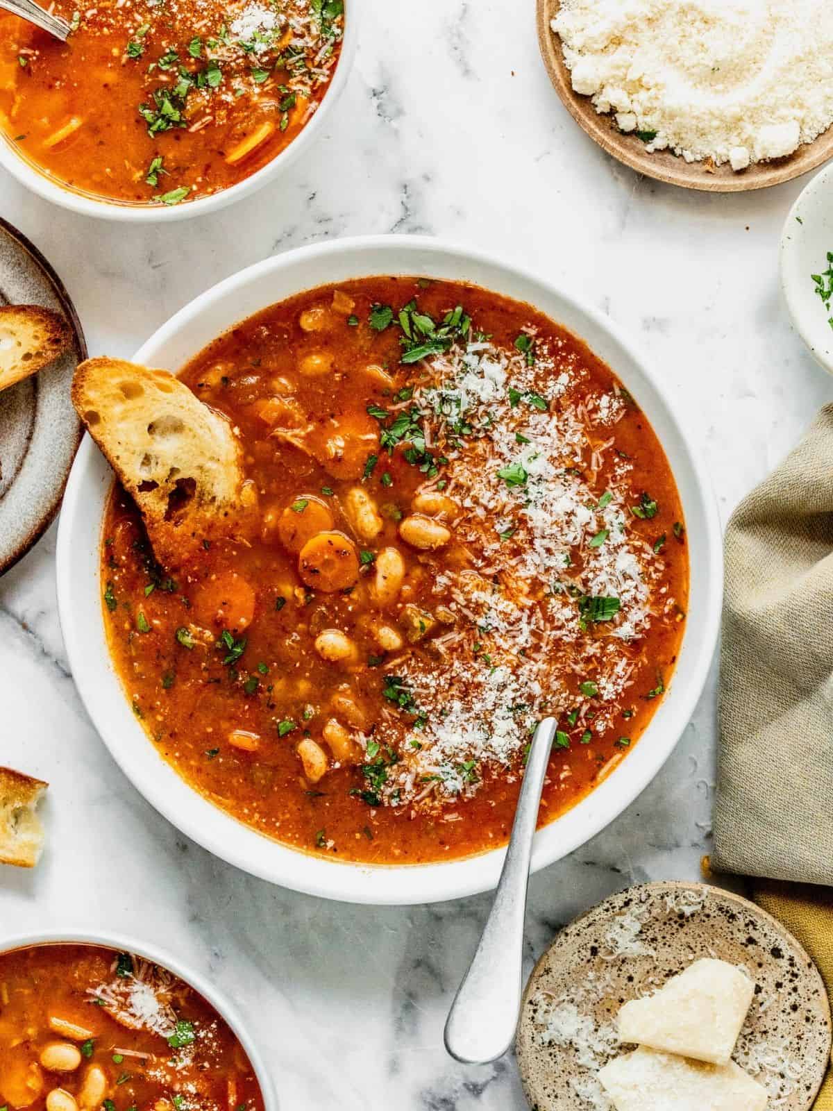 A bowl of fasolada Greek white bean soup garnished with parsley.