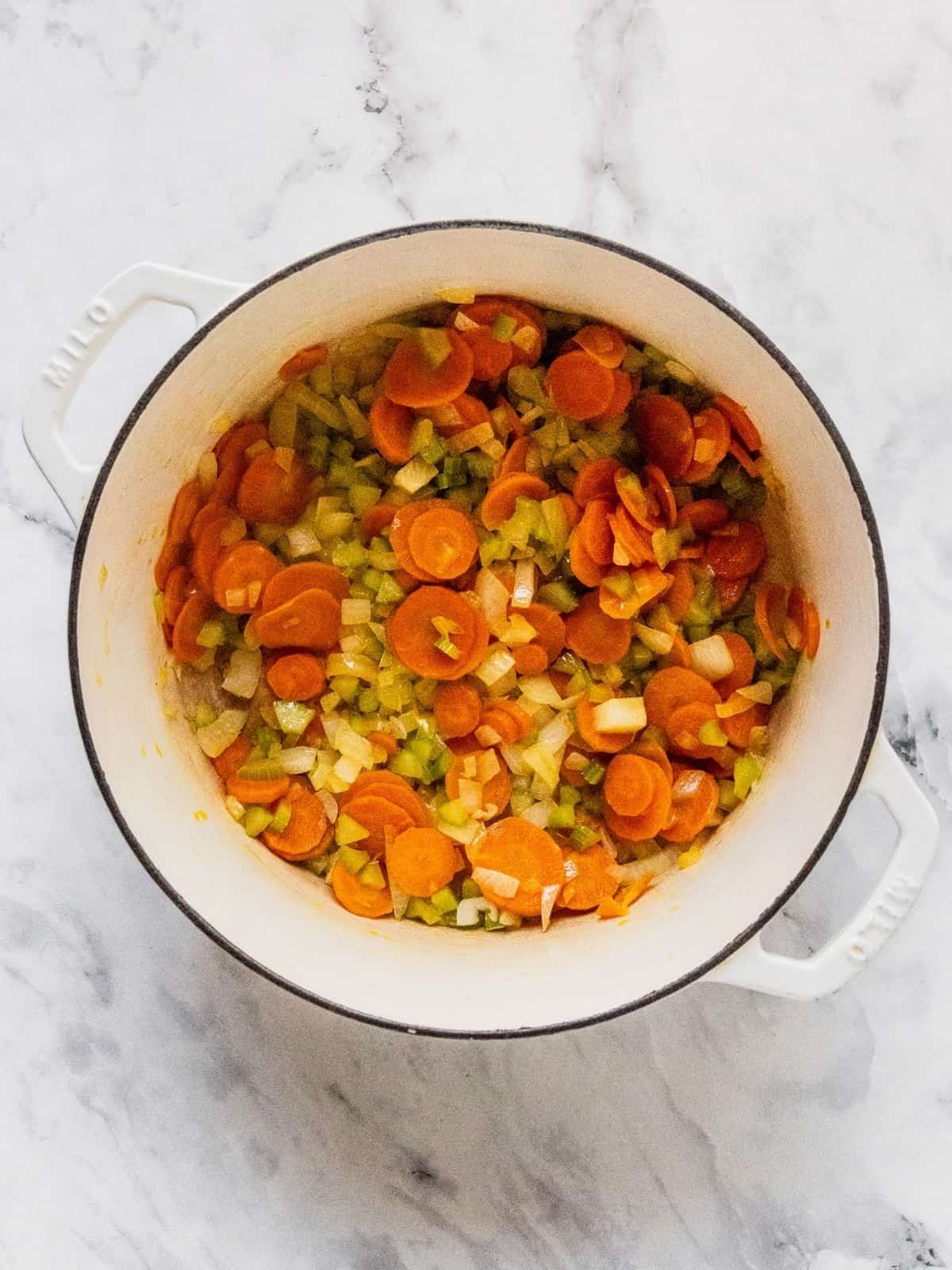 Soup pot with onion, celery and carrot slices.