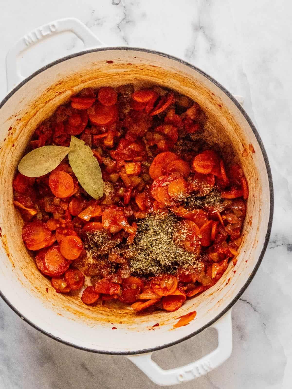 Adding the spices to the soup pot.