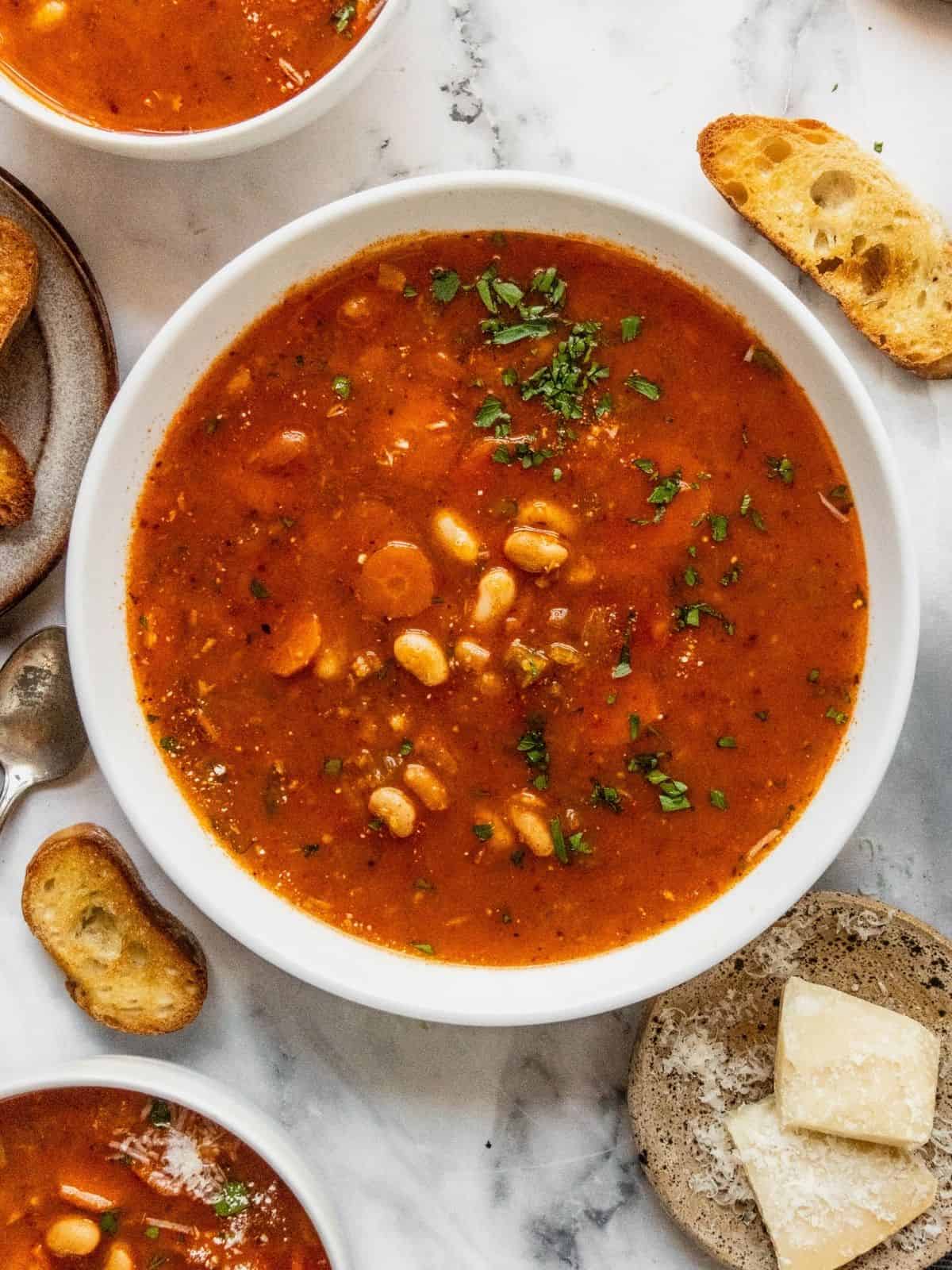 A bowl of fasolada Greek white bean soup garnished with parsley.