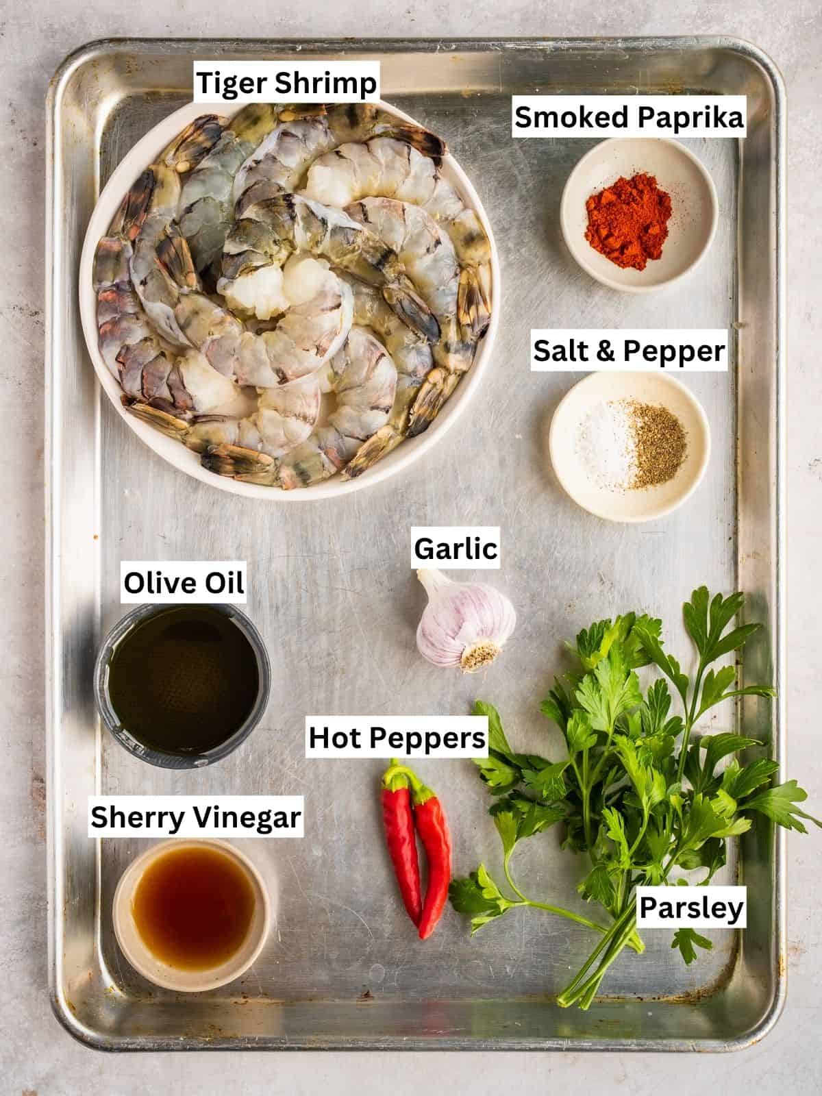 Gambas al ajillo recipe ingredients with individual labels on a metal tray.