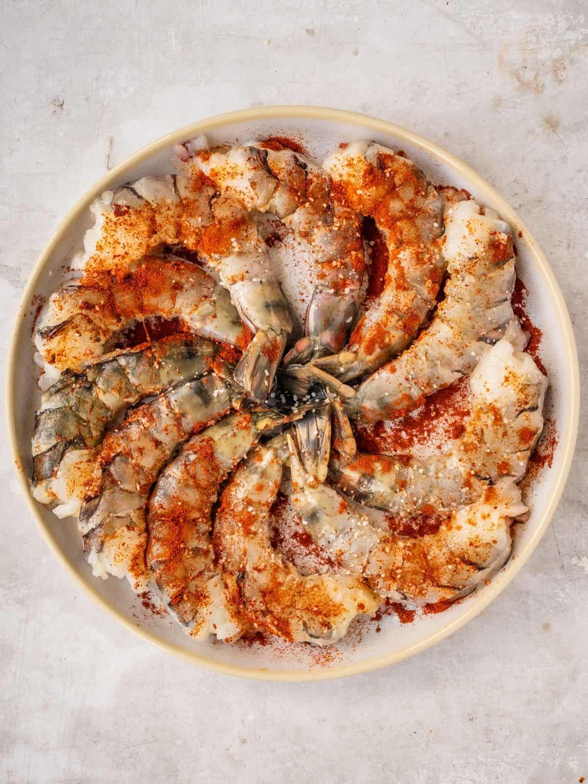 Paprika, salt and pepper seasoned shrimp on a plate.