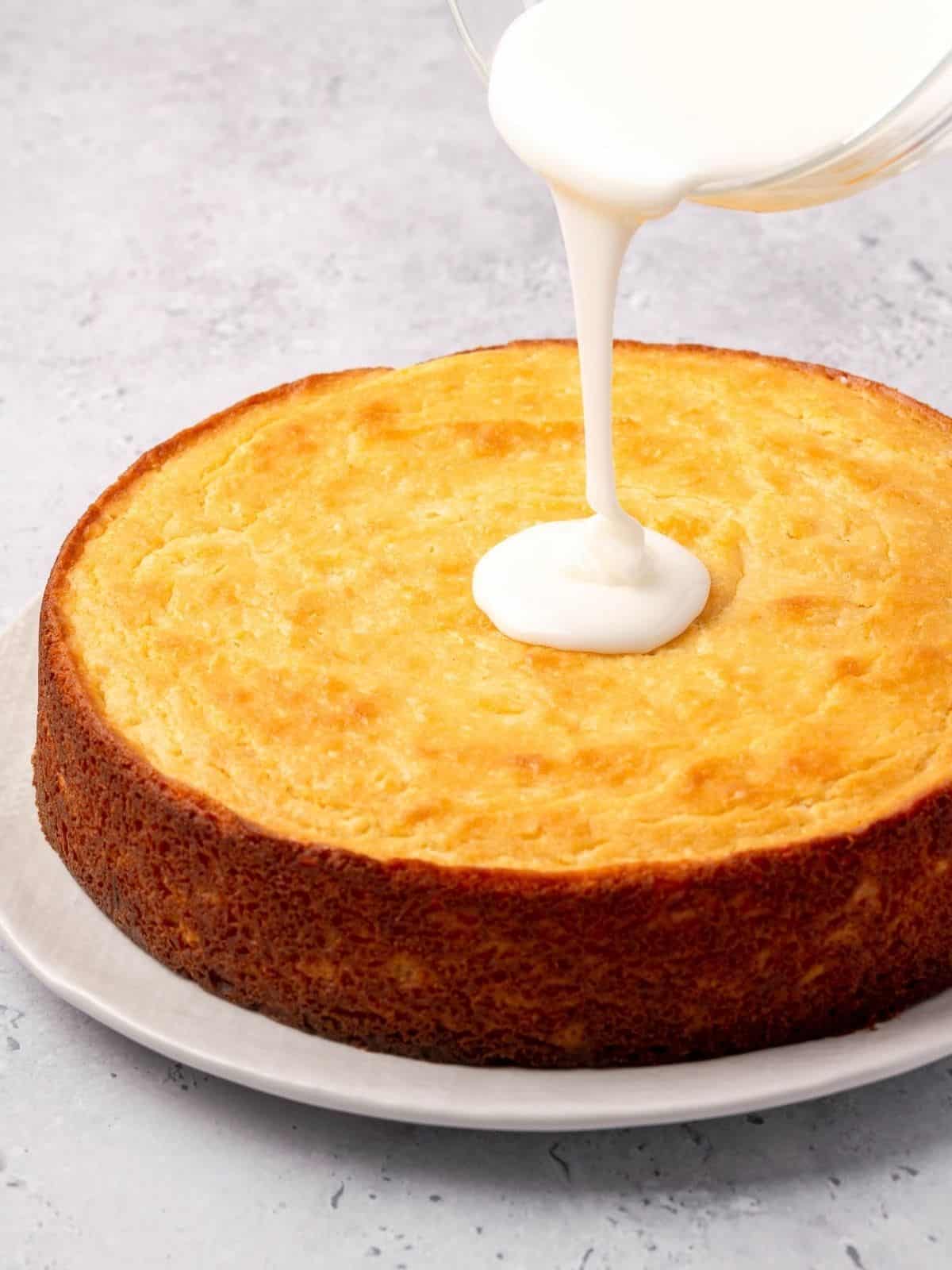 Drizzling icing over the baked and cooled ricotta cake.