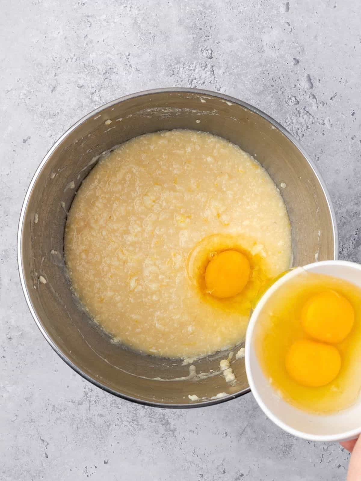 Recipe step showing the eggs getting added to the cake batter.