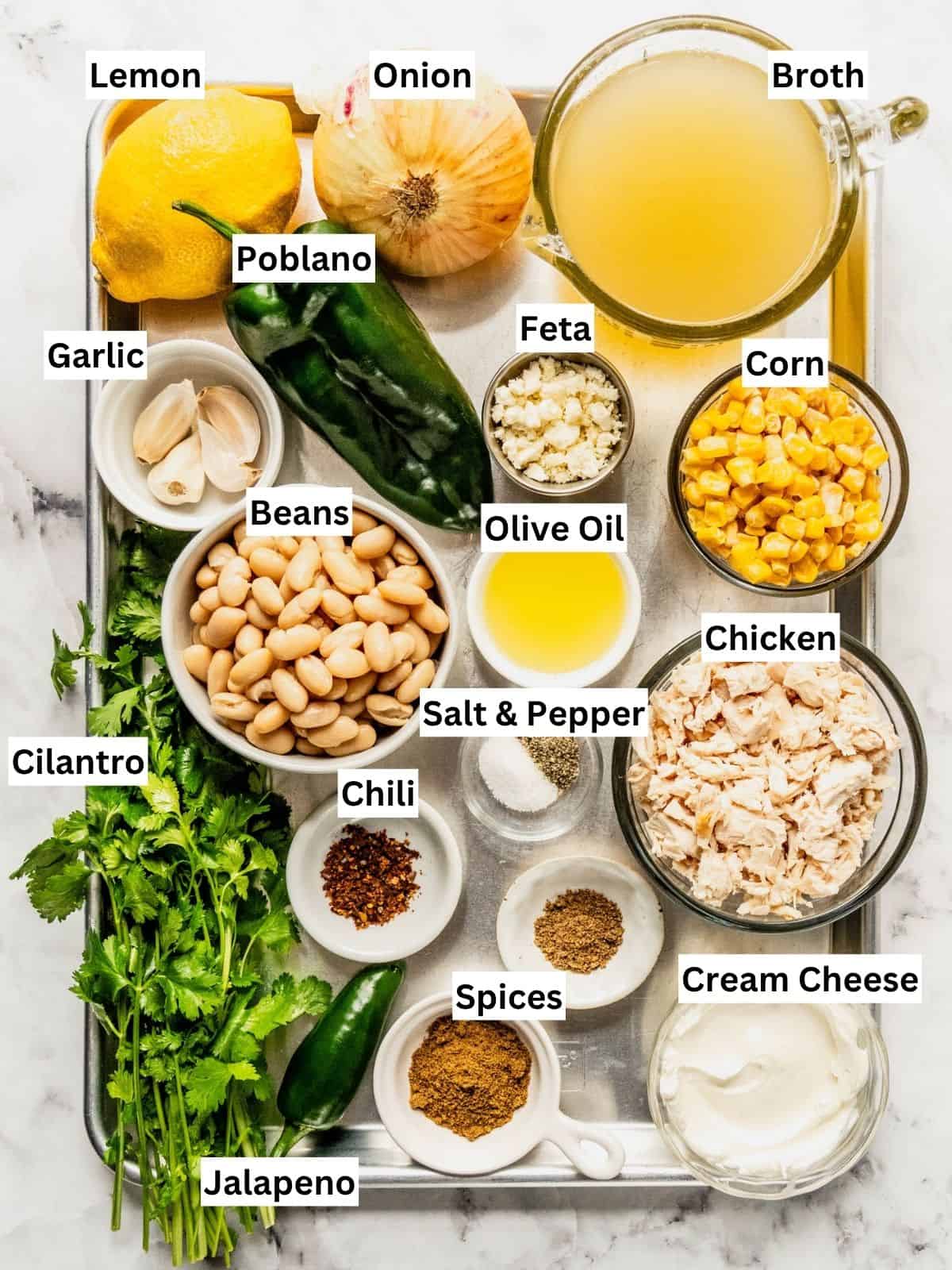 Mediterranean white chicken chili recipe ingredients with individual labels on a metal tray.