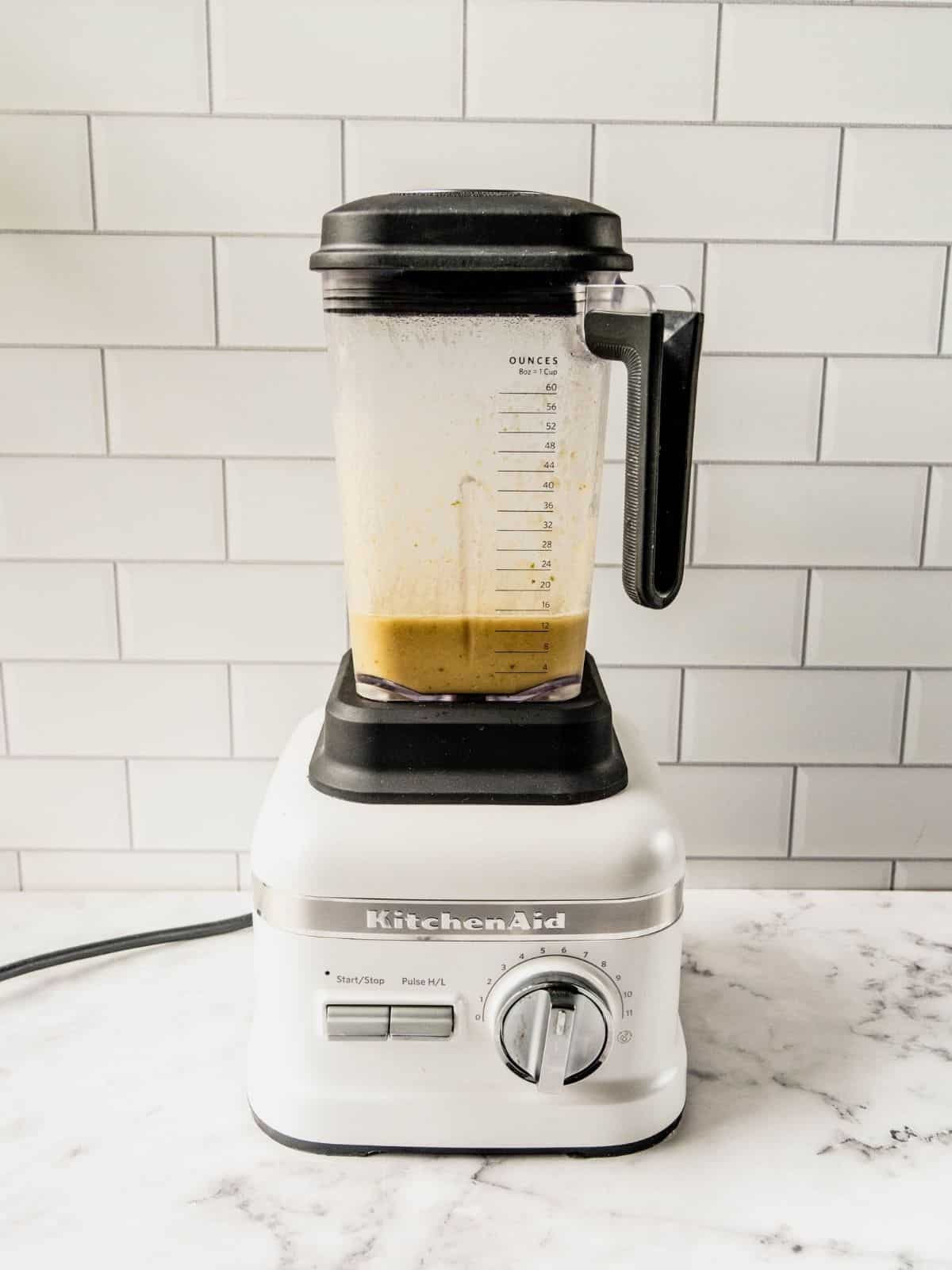 Blender on kitchen counter showing a portion of the blended chili.