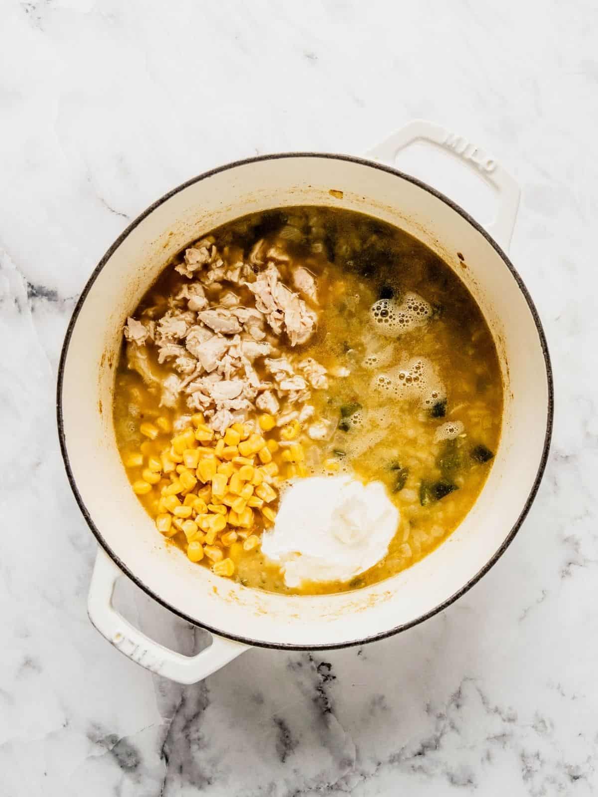 Adding the chicken, cheese and corn into the soup base.