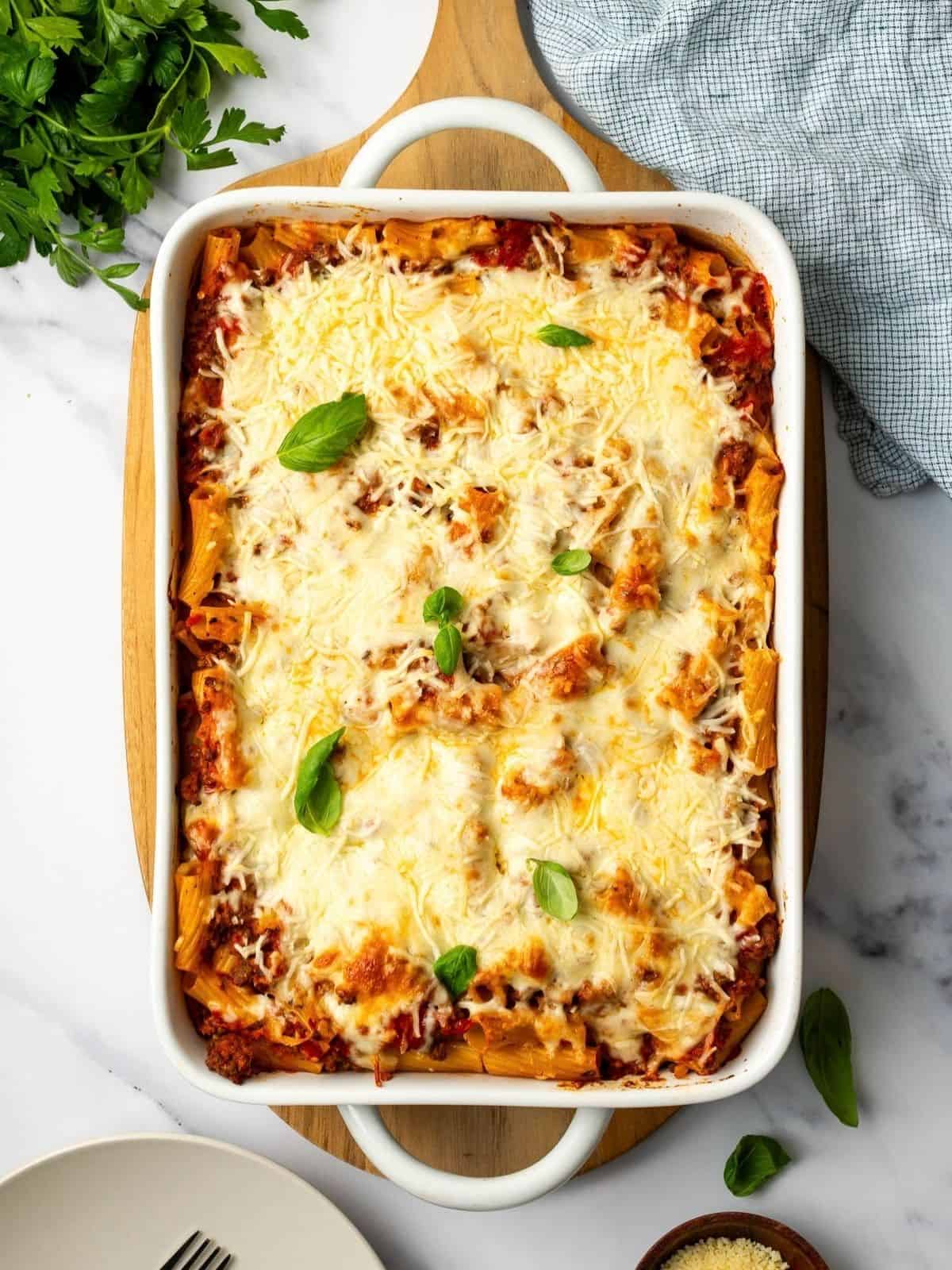Pasta al Forno with Beef in a baking dish garnished with fresh basil.