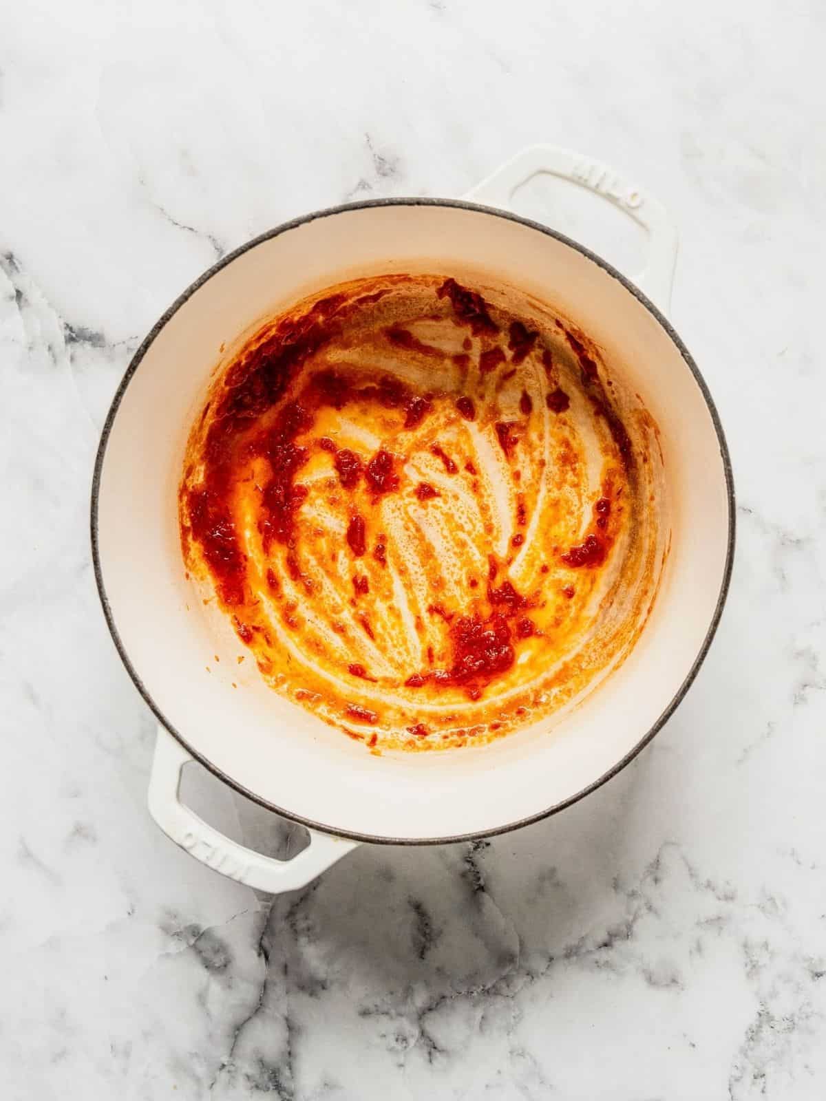 Harissa paste frying in a soup pot.