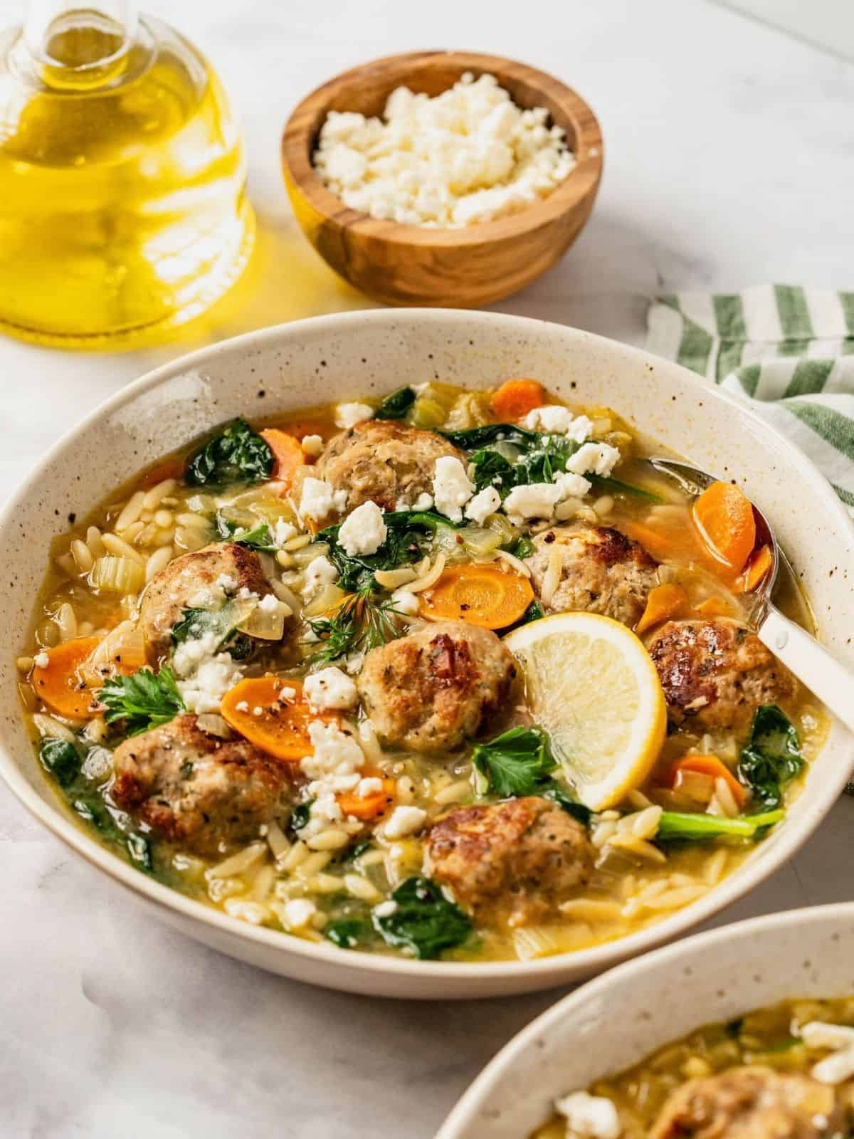 Turkey meatball orzo soup in a bowl garnished with fresh dill and parsley.