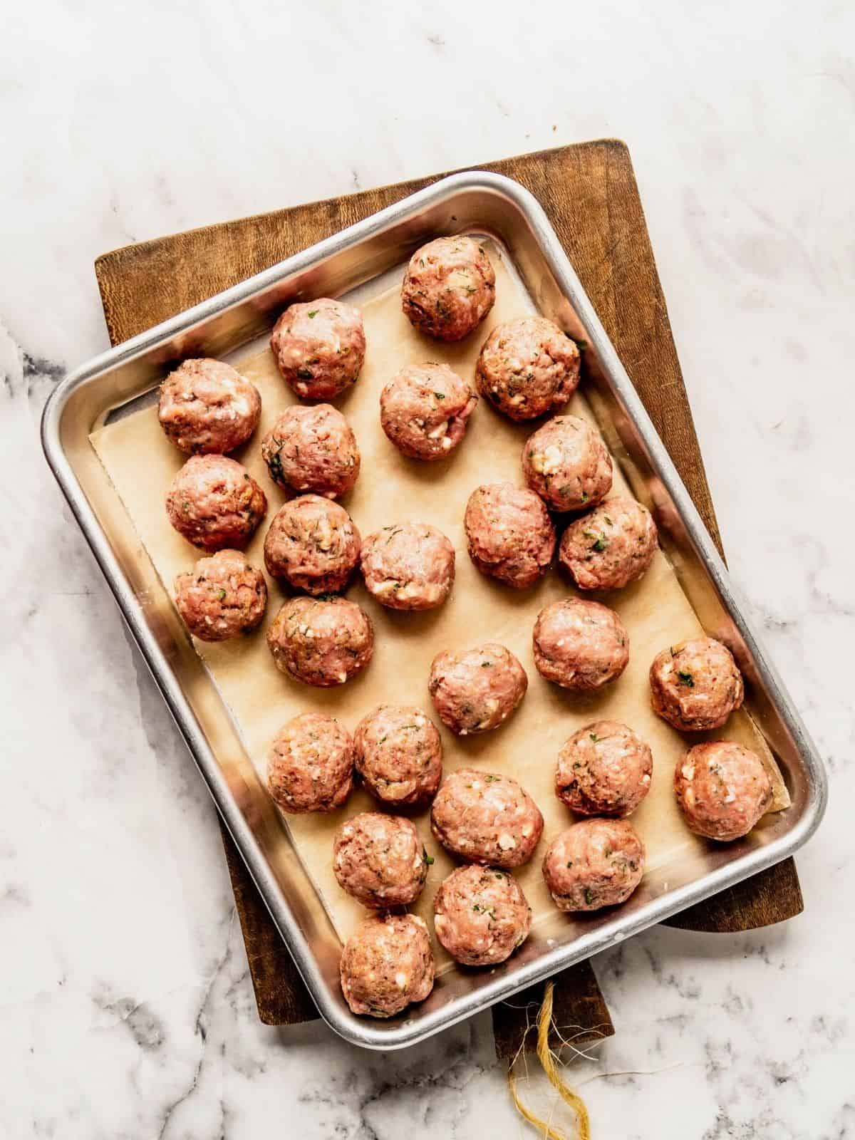 Turkey meatballs on a parchment paper lined baking tray.