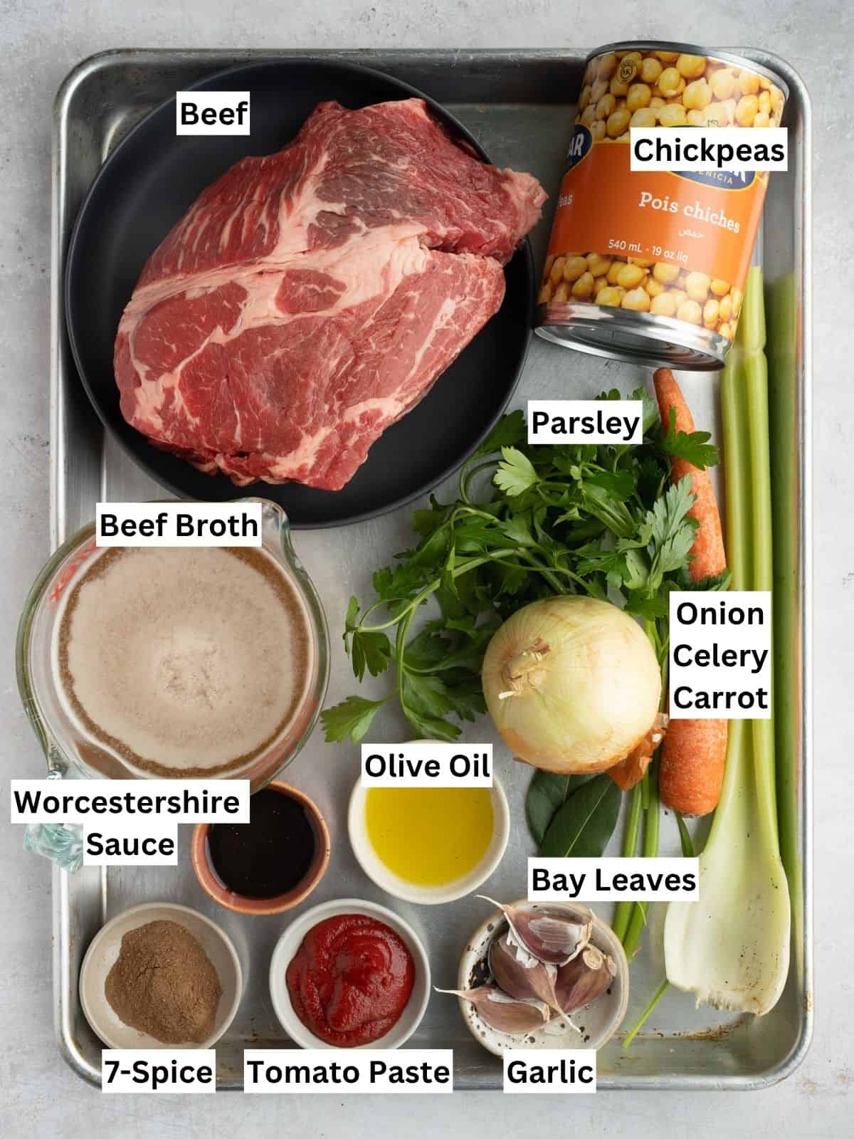 Beef chickpea stew recipe ingredients with individual labels on a metal tray.