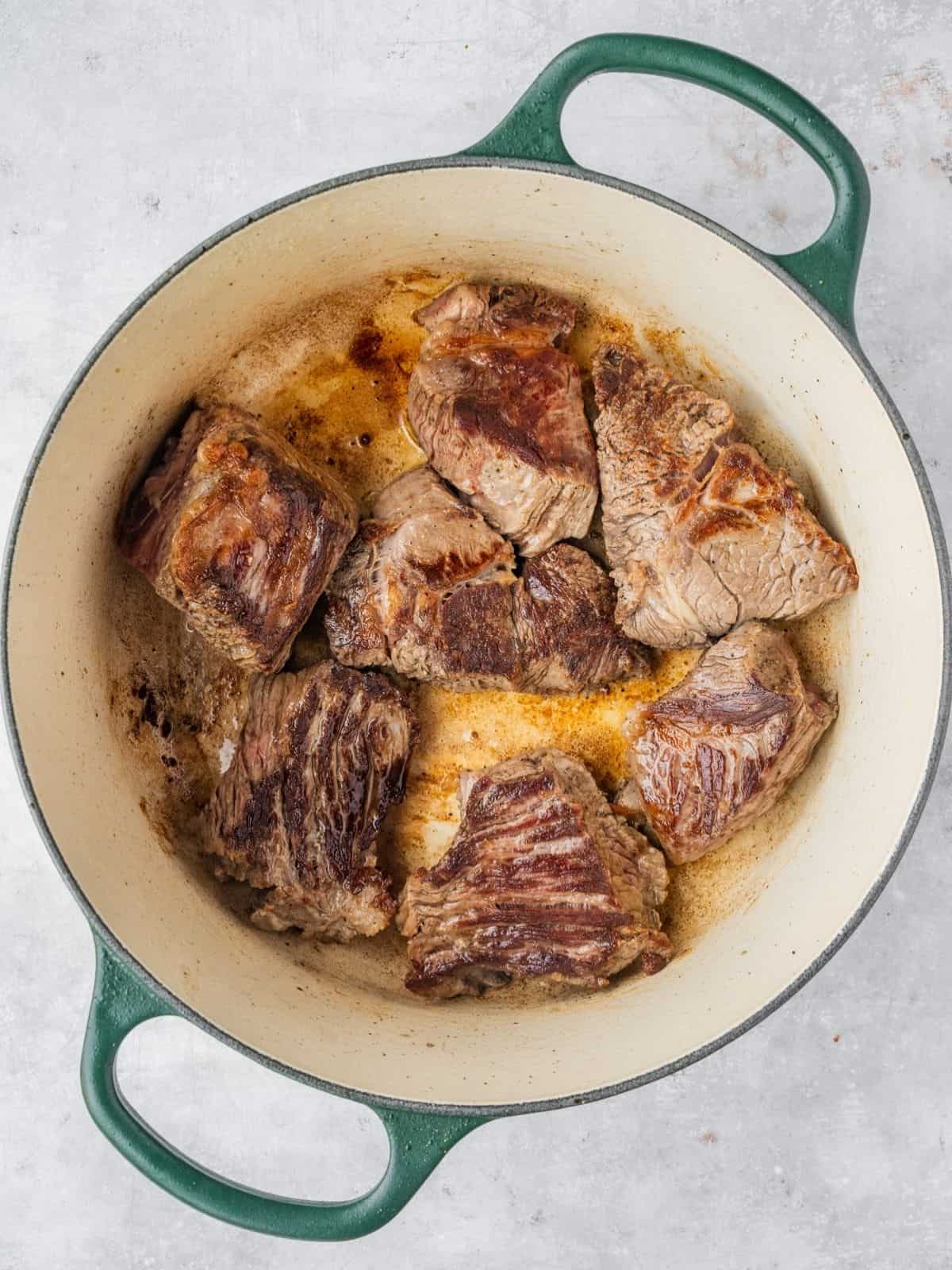 Beef sizzling in a heavy pot.