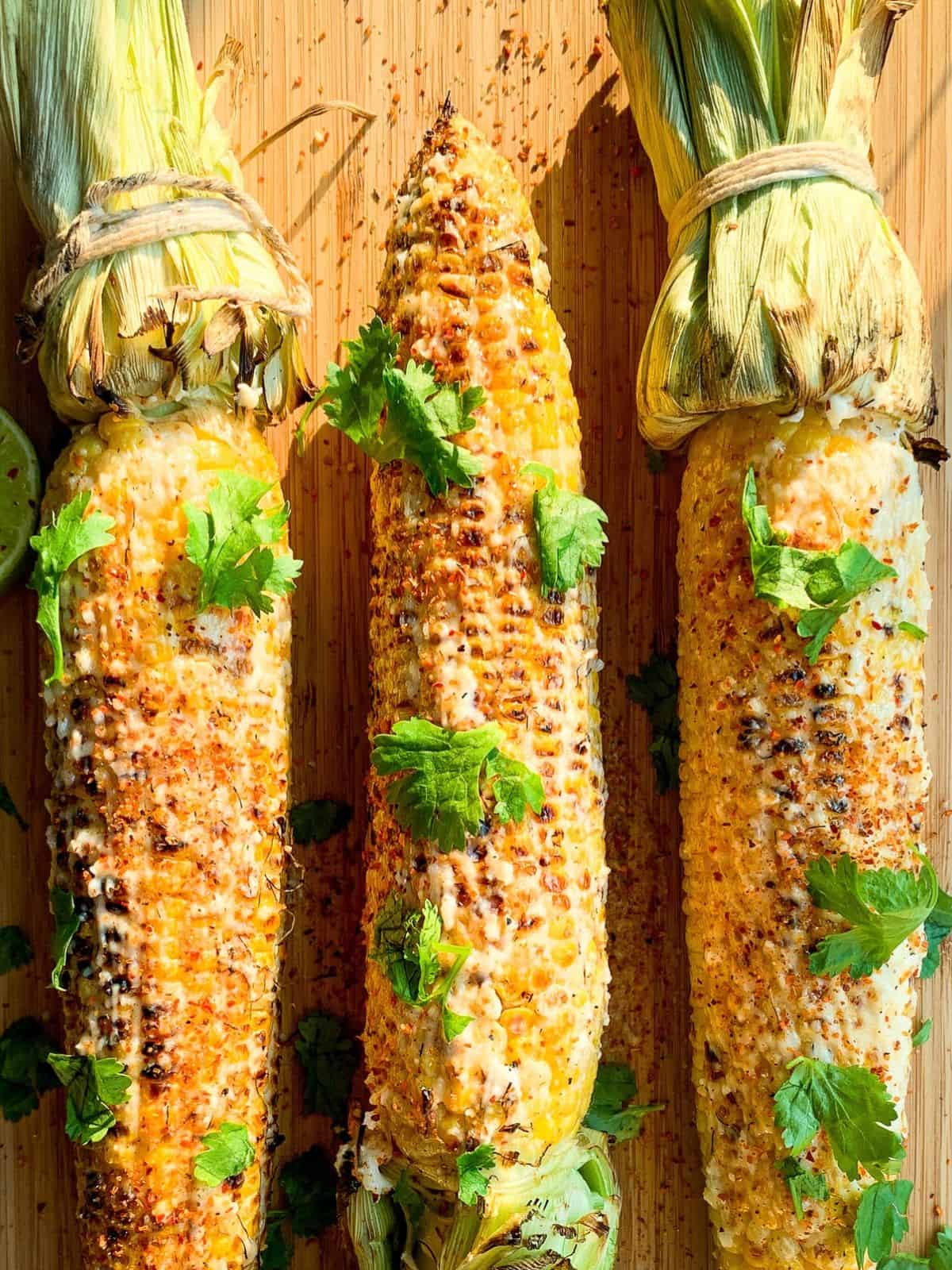 Grilled corn on the cob with cheese, cilantro and lime.